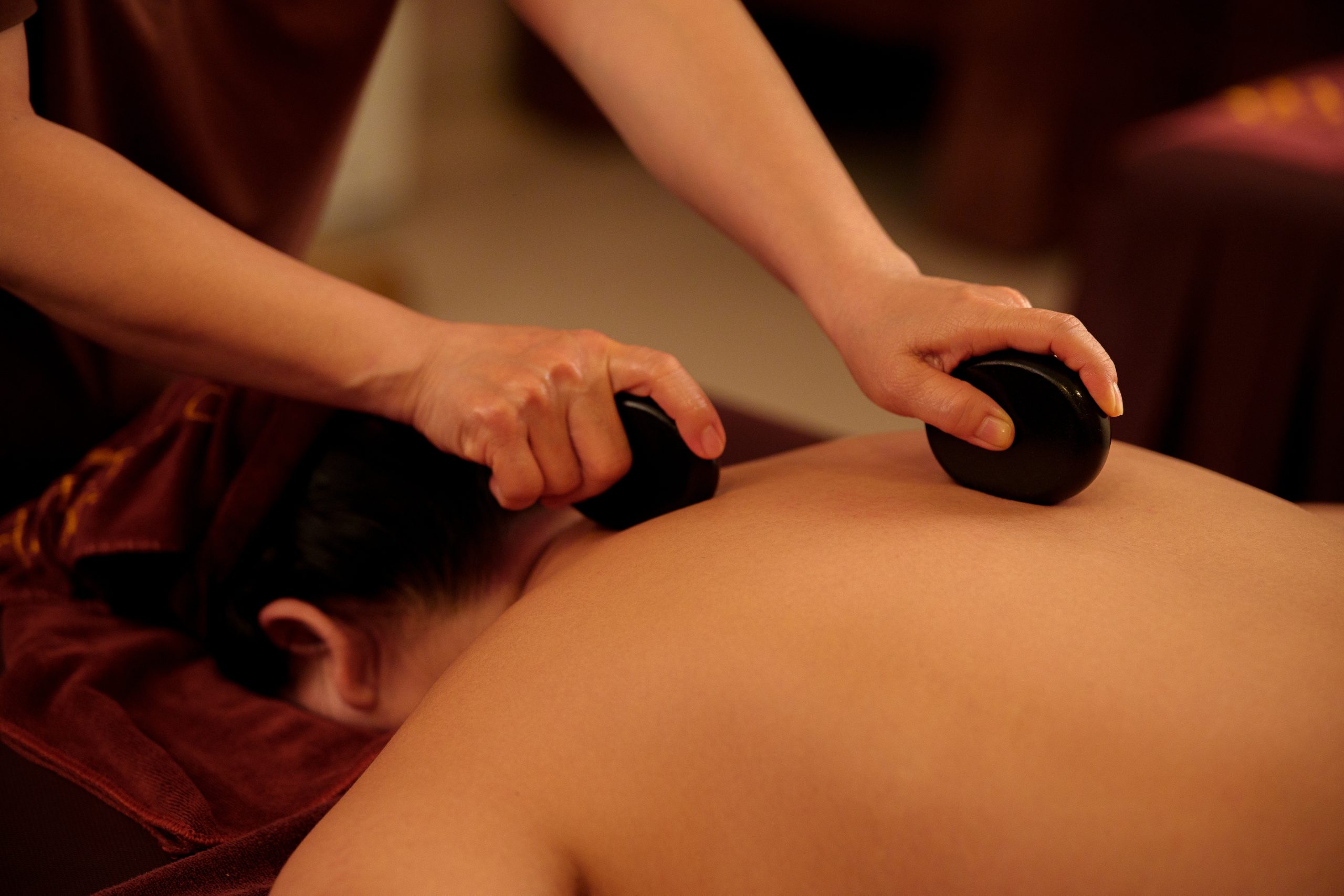 Kỹ thuật viên Tỉnh Thức Spa khéo léo dùng đá nóng miết trượt dọc theo thớ cơ lưng, xoa dịu co thắt êm ái