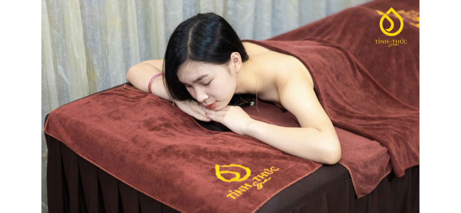 Khách hàng thư giãn thanh thản trên giường massage bọc nệm êm ái tại Tỉnh Thức Spa