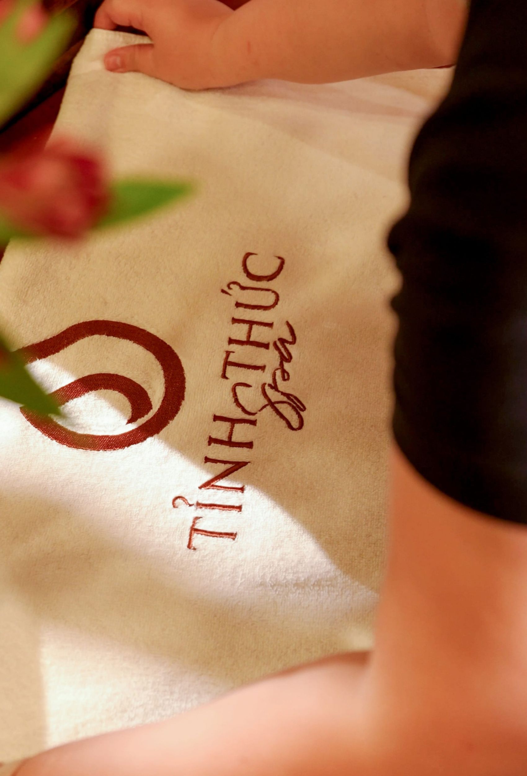 Chuẩn bị giường nằm spa ấm cúng, tinh tươm với khăn thêu logo Tỉnh Thức Spa