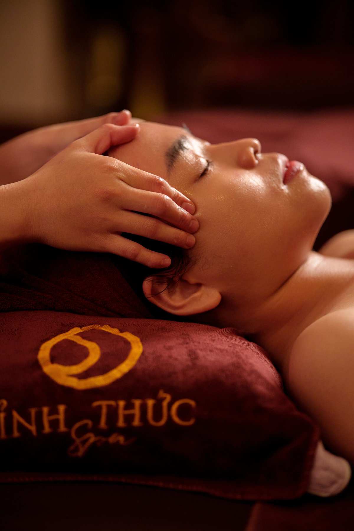 Khách hàng thả lỏng thư thái khi kỹ thuật viên massage thư giãn vùng trán và thái dương tại Tỉnh Thức Spa